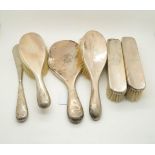 A six piece silver vanity set, comprising a hand mirror, two clothes brushes, two hair brushes,