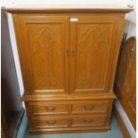 A 20th century teak linen press with two gothic style panel doors concealing shelves and three linen