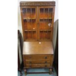 A 20th century oak bureau bookcase with pair of glazed doors above fall front above three drawers on