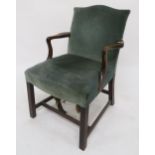 A late Georgian beech framed open armchair with green velour upholstered back and seat on