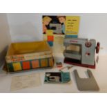 A Vulcan Classic child's electric sewing machine (battery operated) with an advertisement