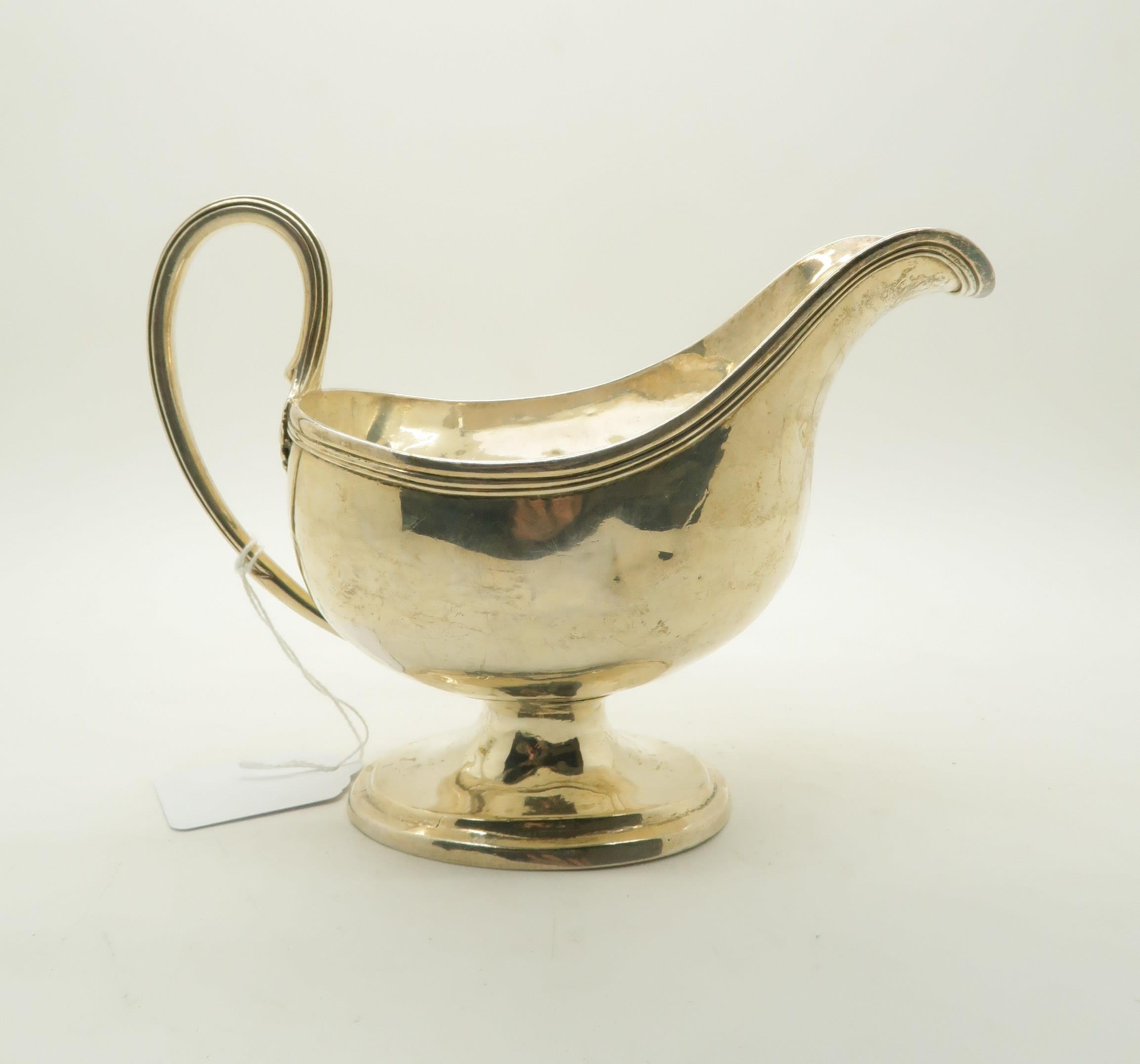 A George III silver sauce boat, with reeded handle and rim, on a stepped oval base, possibly by