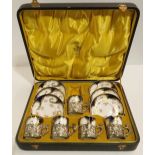 A set of boxed unmarked coffee cans and saucers, with silver cup mounts, one cup missing Condition