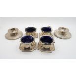 A set of four George V silver salts, of canted form, with blue glass liners, by Cooper Brothers &