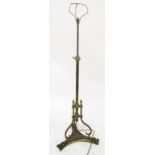A brass adjustable standard lamp on scrolled tripod base Condition Report:Available upon request