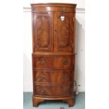 A 20th century mahogany two door drinks cabinet on three drawer base, 132cm high x 57cm wide x