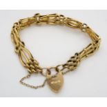A 9ct yellow gold fancy link gate bracelet with heart shaped clasp and safety chain, 18cm long, 15.