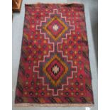 A red ground Balouch rug with dual central medallion and multicoloured border, 134cm long x 86cm