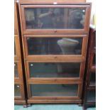 A 20th century hardwood four tier fall front glazed bookcase on paw feet, 166cm high x 90cm wide x