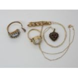 A collection of yellow metal items to include a clear gem set ring, a curblink brooch, a garnet