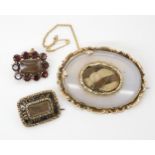 A yellow metal hair mourning brooch set with garnets, a further yellow metal agate and plaited