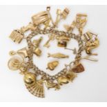 A 9ct gold charm bracelet with twenty-two fully hallmarked attached charms and two loose, weight