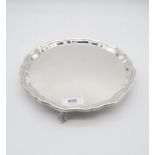 An Elizabeth II silver salver, with scalloped rim, on three ball and claw feet, by Charles S Green &