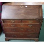 A Georgian oak writing bureau with fitted fall front writing compartment above two over three