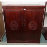 A modern Oriental style drinks cabinet with pair of shelved doors concealing fitted interior,