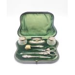 An Edwardian cased silver manicure set, the utensils and bottles decorated with Reynolds Angels,