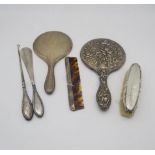 A collection of silver including a silver hand mirror with engine turned decoration surrounding a