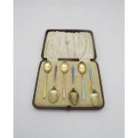 A cased set of silver gilt and harlequin guilloche enamel coffee spoons, by William Suckling Ltd,