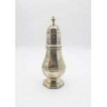 A large George VI silver sugar caster, of faceted baluster form, with faceted finial, on a footed