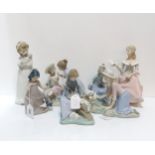 A Nao figure of a girl playing with rabbits, another two playing with dogs, another with a dove, a