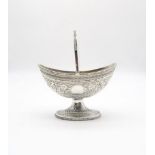 A fine Victorian silver swing handled sugar basket, of boat shaped form with repousse scrolling