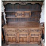A 20th century oak kitchen dresser with plate rack above three drawers over three cabinet doors (