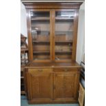 A late Victorian oak glazed two door bookcase on cabinet base, 240cm high x 128cm wide x 59cm deep