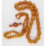 Two strings of yellow amber coloured beads, largest weight 80.8gms, smaller 20.3gms, together