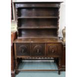 A 20th century oak kitchen dresser with three tier plate rack above three cabinet doors on turned