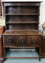 A 20th century oak kitchen dresser with three tier plate rack above three cabinet doors on turned
