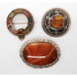 Two Scottish inlaid agate brooches, one stamped Sterling Scotland, and a further white metal