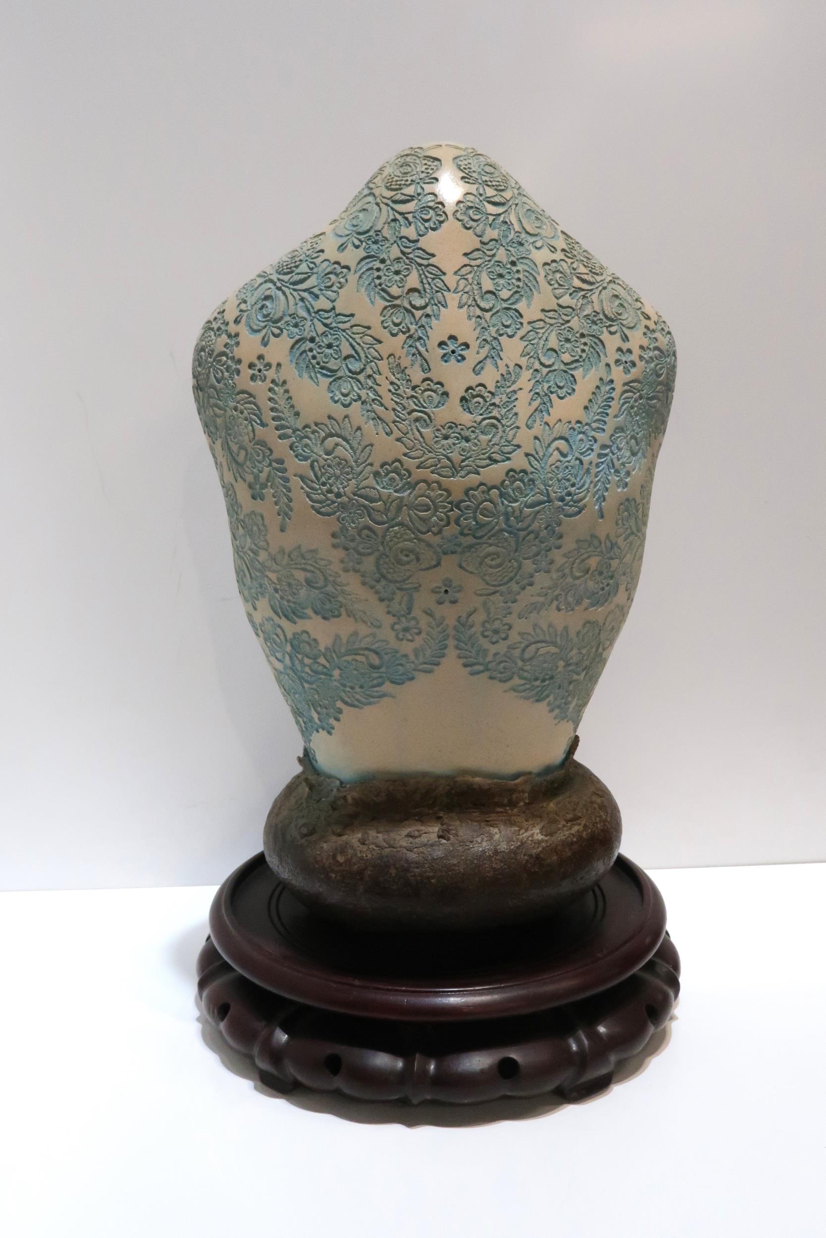 A ceramic bust with impressed blue floral decoration, with a modelled brown base, upon a hardwood - Image 2 of 2