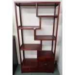 A modern Oriental style display shelf with four asymmetrical shelves above single drawer and cabinet