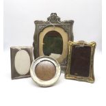 An Edwardian silver photo frame, of shaped form, the frame surrounded by moulded floral borders,