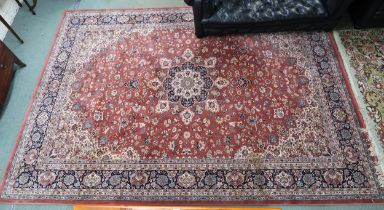 A modern terracotta ground Keshan style rug with floral central medallion, matching spandrels and
