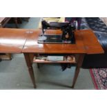 A 20th century mahogany cased Singer electric sewing machine with single drawer on square tapering