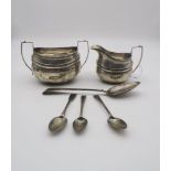 A collection of silver including a silver cream jug and sugar bowl with banded decoration and a