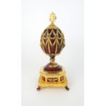 A FRANKLIN MINT MUSICAL GOLD PLATED SILVER FABERGE IMPERIAL EAGLE EGG with red guilloche enamel