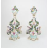 A PAIR OF MEISSEN URNS AND COVERS each with painted and encrusted flowers and cherubs, upon