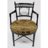 A VICTORIAN EBONISED CHAIR IN THE MANNER OF E.W. GODWIN with foliate upholstered seat, fretwork back