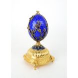 A HOUSE OF IGOR CARL FABERGE MUSICAL SILVER GILT FIREBIRD EGG set with red gems and elements of