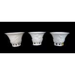 THREE CHINESE BLANC DE CHINE LIBATION CUPS each moulded with blossoming branches, 6 to 6.5cm high (