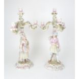 A PAIR OF MEISSEN STYLE CANDELABRAS each with a figure below floral encrusted candle arms, 52cm high