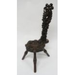 A VICTORIAN OAK SPINNING CHAIR with extensively carved seat and back depicting a stylistic