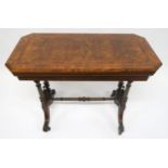 A VICTORIAN BURR WALNUT FOLDOVER CARD TABLE with turned supports and stretcher on shaped out swept