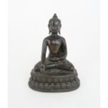 A CHINESE BRONZE MODEL OF BUDDHA of traditional type and raised on a lotus throne, 13cm high
