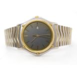 A GENTS EBEL WRISTWATCH with gold bezel grey dial with gold coloured baton numerals and a date