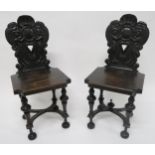 A PAIR OF VICTORIAN OAK HALL CHAIRS with carved backs depicting lions rampant flanking central
