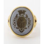 A BRIGHT YELLOW METAL INTAGLIO RING set with a carved sardonyx with a family crest featuring a swan.