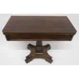A VICTORIAN ROSEWOOD FOLDOVER TEA TABLE with central square tapering column support on quatrefoil